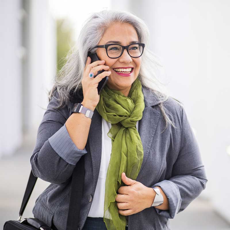 Satisfied hearing aid user talking on phone